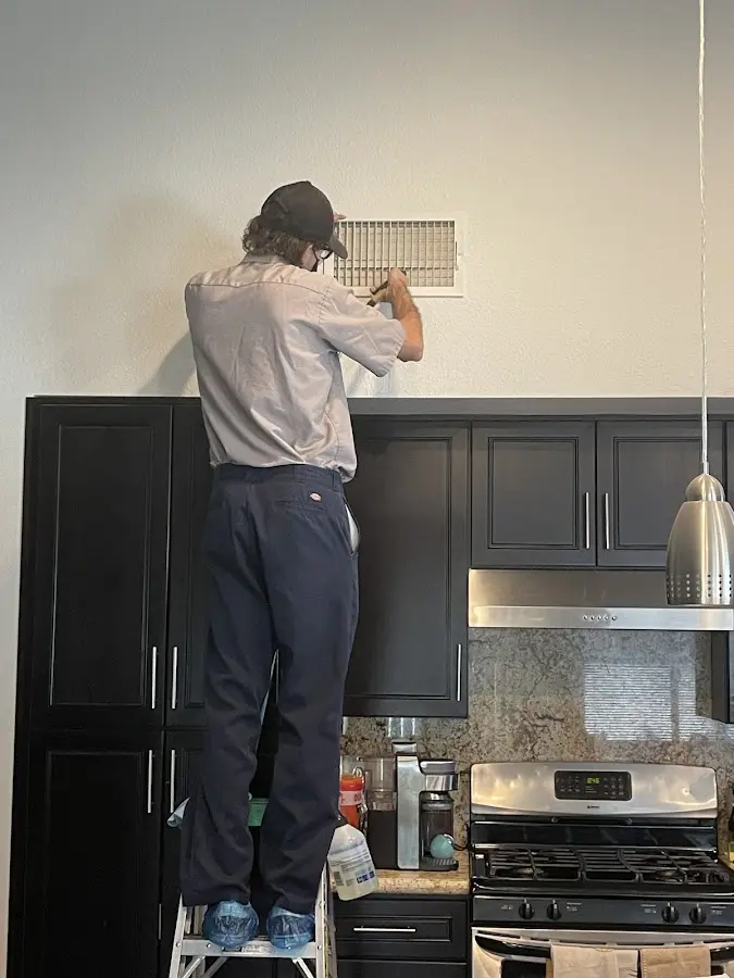 Technician inspecting an air vent during HVAC service in Richfield